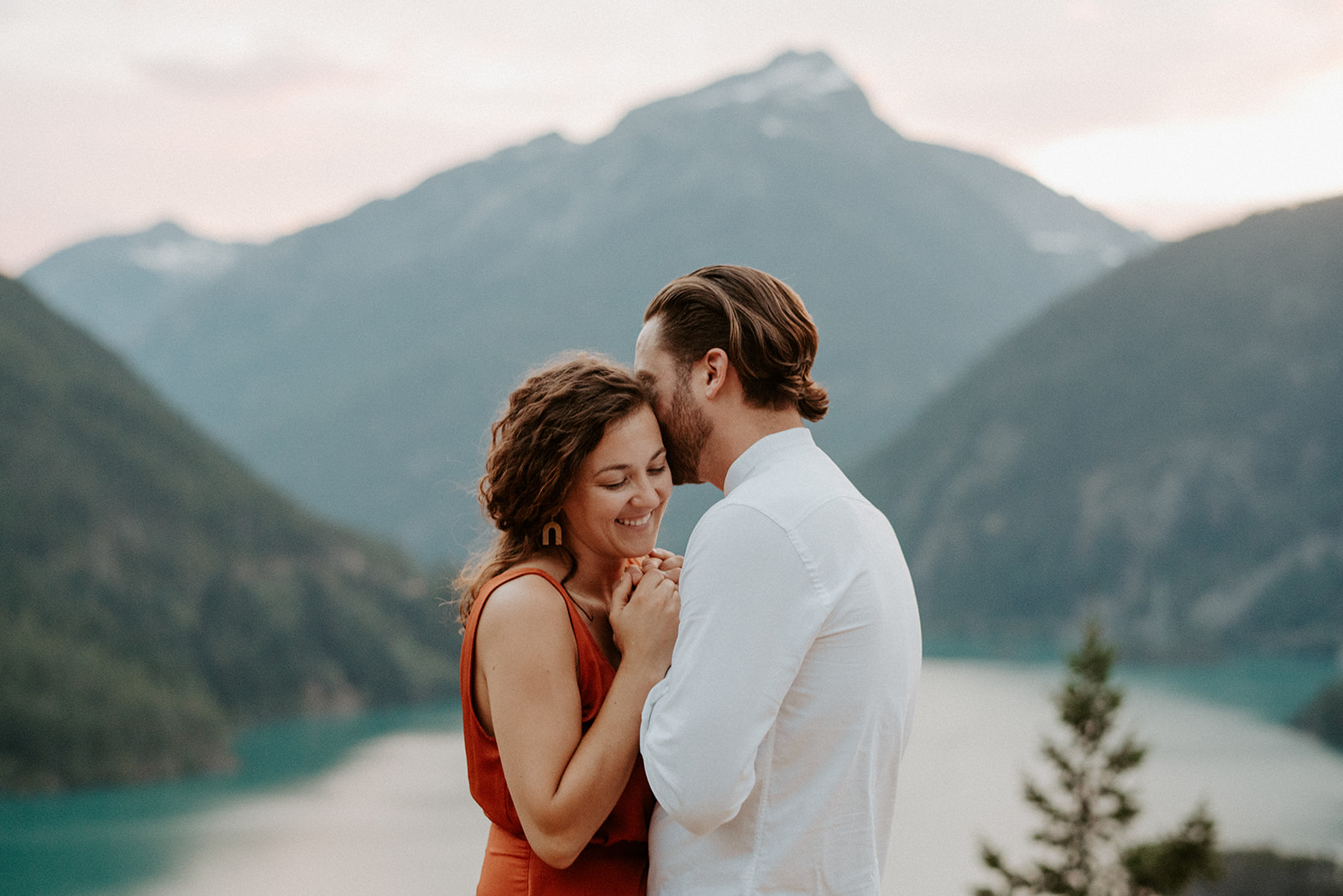 stunning couple standing closely with a mountain view in background