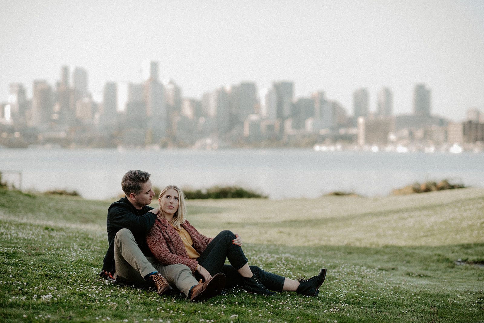 beautiful couple sitting in a park near a lake