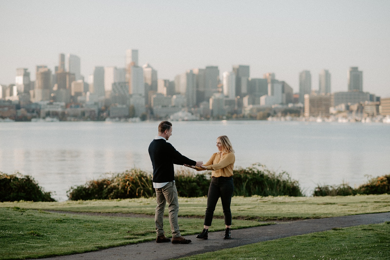Couple spinning and laughing with the Seattle skyline across Lake Union
