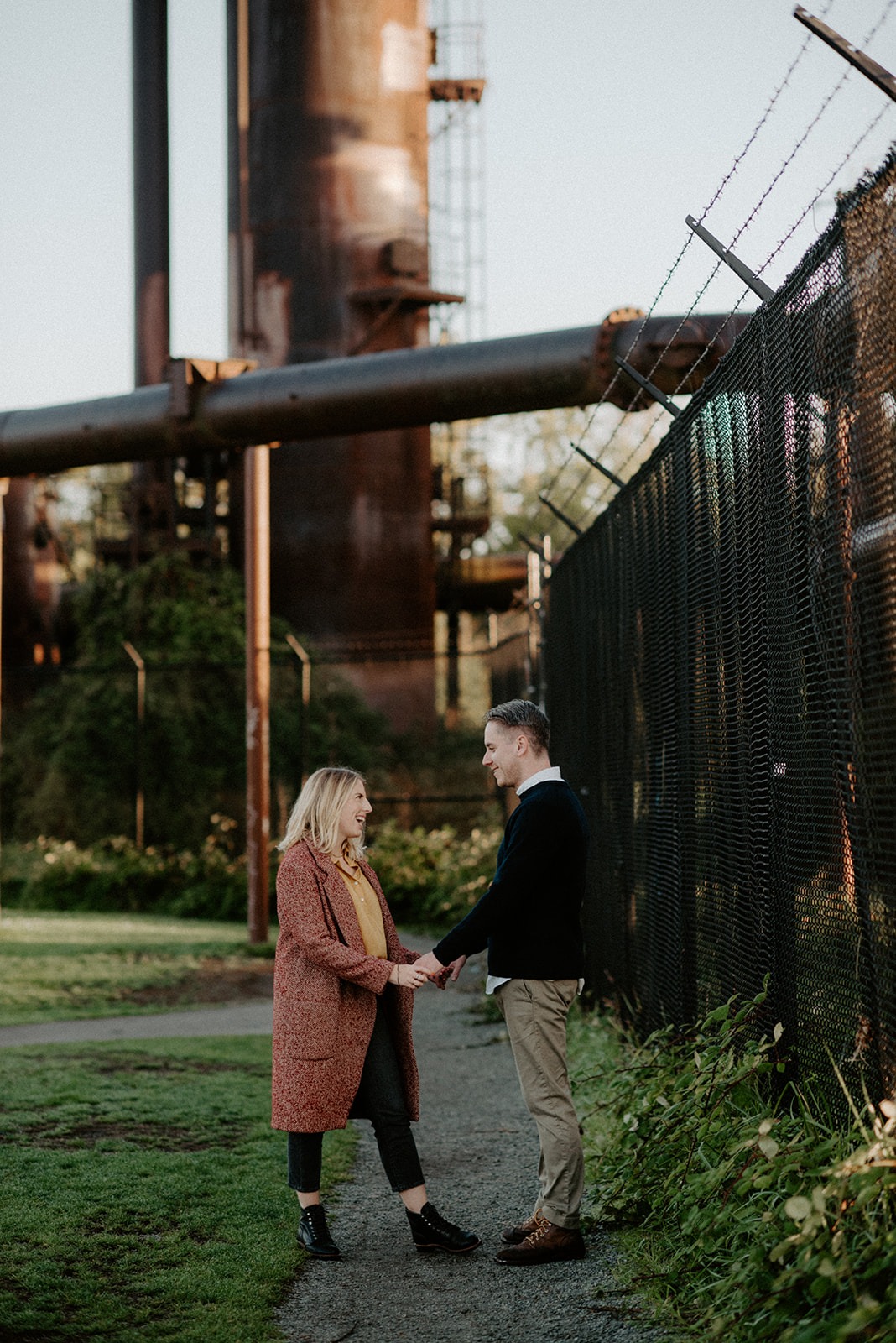 Couple holding hands beneath the industrial structures at Gas Works Park