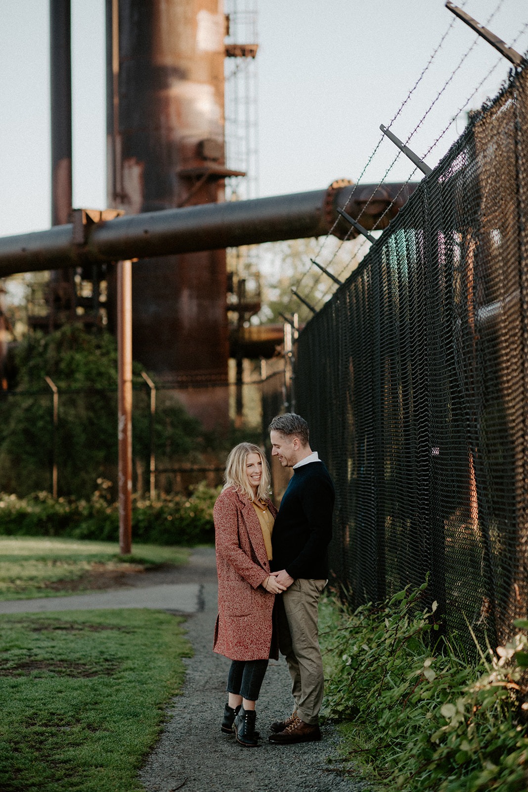 Couple standing together on a waterfront path with the Seattle skyline behind them