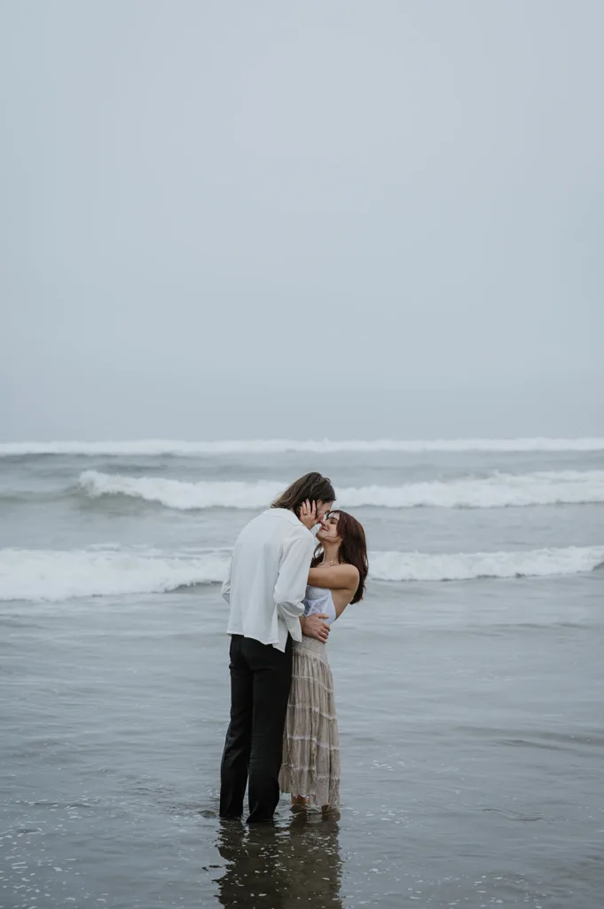 Couple embracing in the shallow waves on the Oregon coast