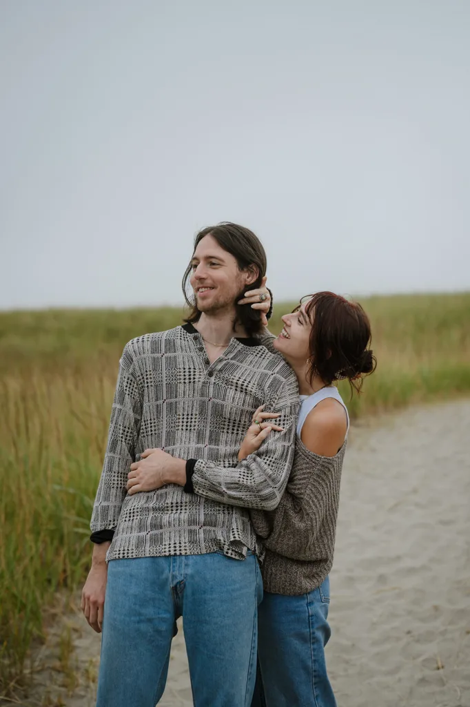 Laughing couple sharing a joyful moment during their Oregon coast engagement shoot
