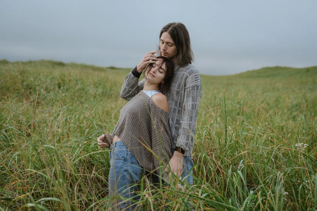 Couple embracing among tall beach grass on the Oregon coast