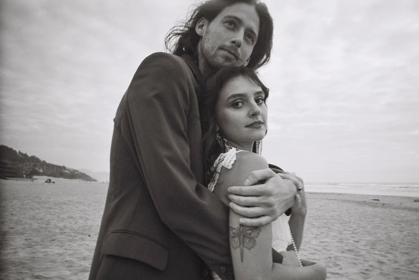 Vintage-style film photo of a couple embracing on a sandy beach