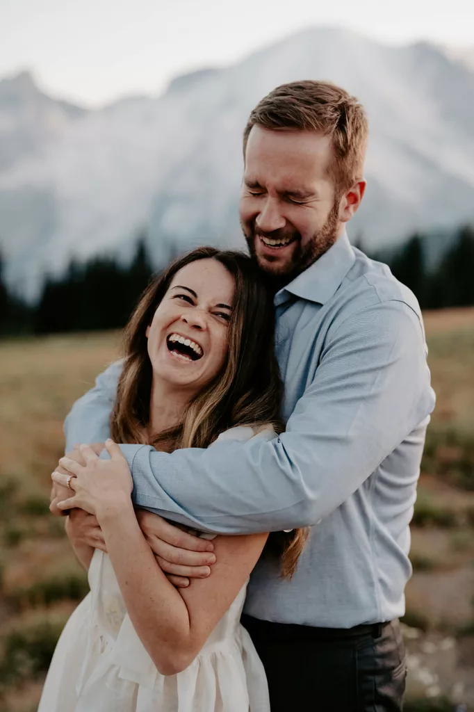 beautiful engagement couple sharing big smiles and laughs holding each others