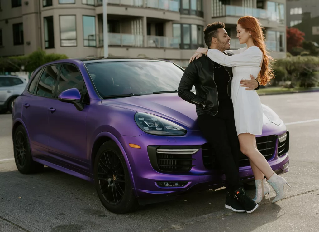 romantic wedding couple, men holding her waist women holding his shoulders standing ahead of a purple car