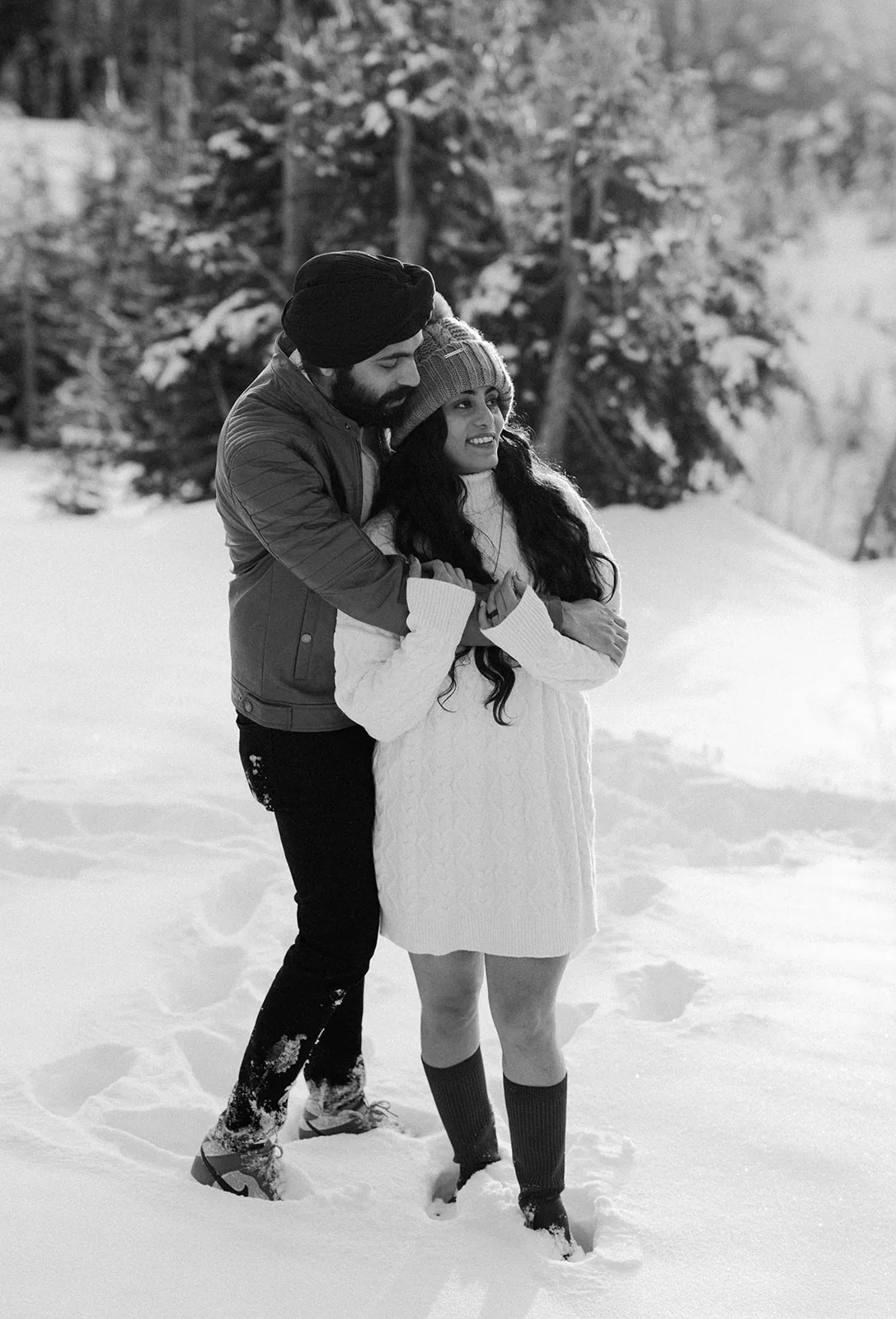 Black and white winter engagement photo of couple embracing in fresh snow at Mount Rainier
