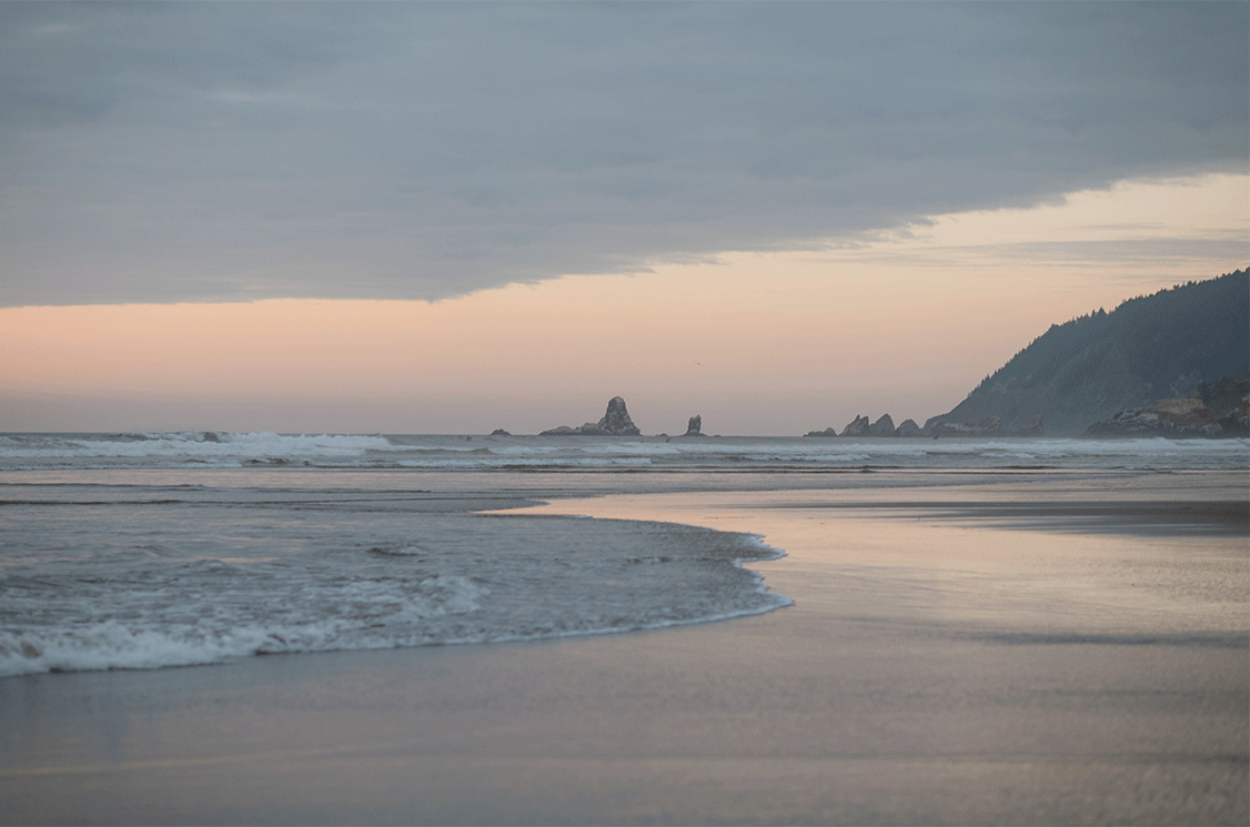 Gentle waves lapping the shore at sunset on the Oregon coast