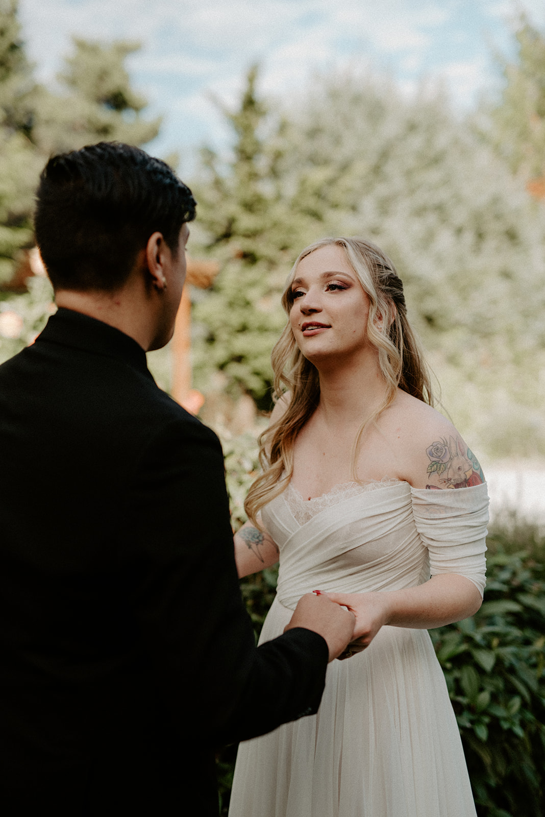 Bride smiling tenderly at her groom in the moments after their first look in the Willows Lodge garden