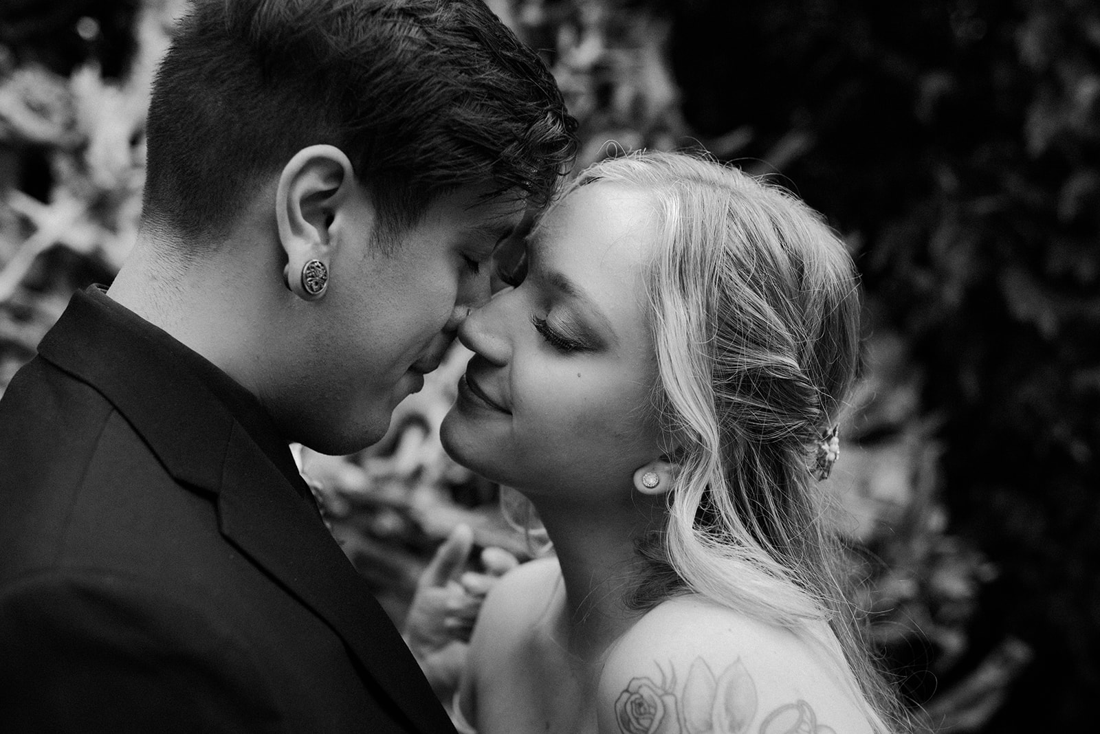 Black and white close portrait of a bride and groom sharing a kiss, soft and intimate