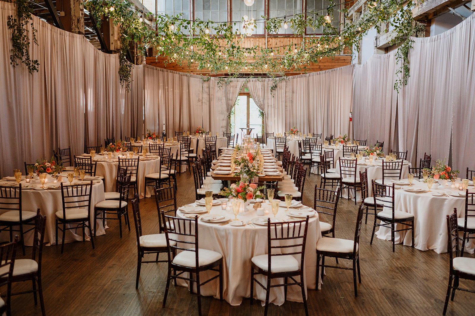 Elegantly decorated reception space with round tables, floral centerpieces, and string lights at Sodo Park.