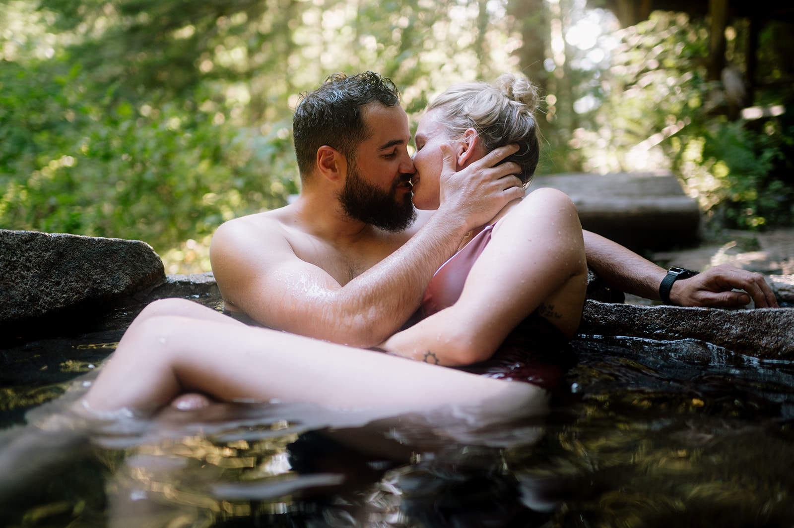 R and M in a close embrace in the hot springs, enjoying a private moment.