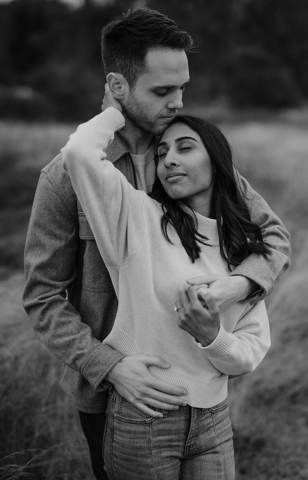 Couple embracing at Discovery Park during their engagement session.