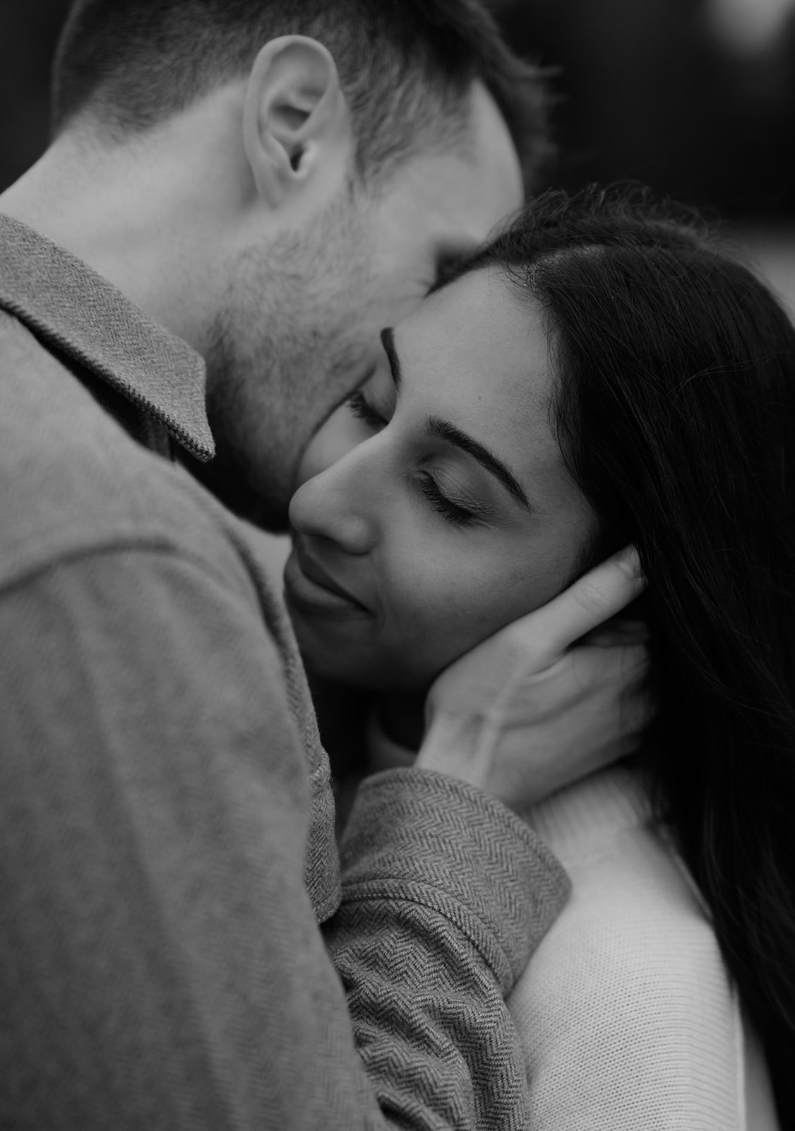 Close-up of a couple sharing an intimate moment, leaning in close during their fall session.