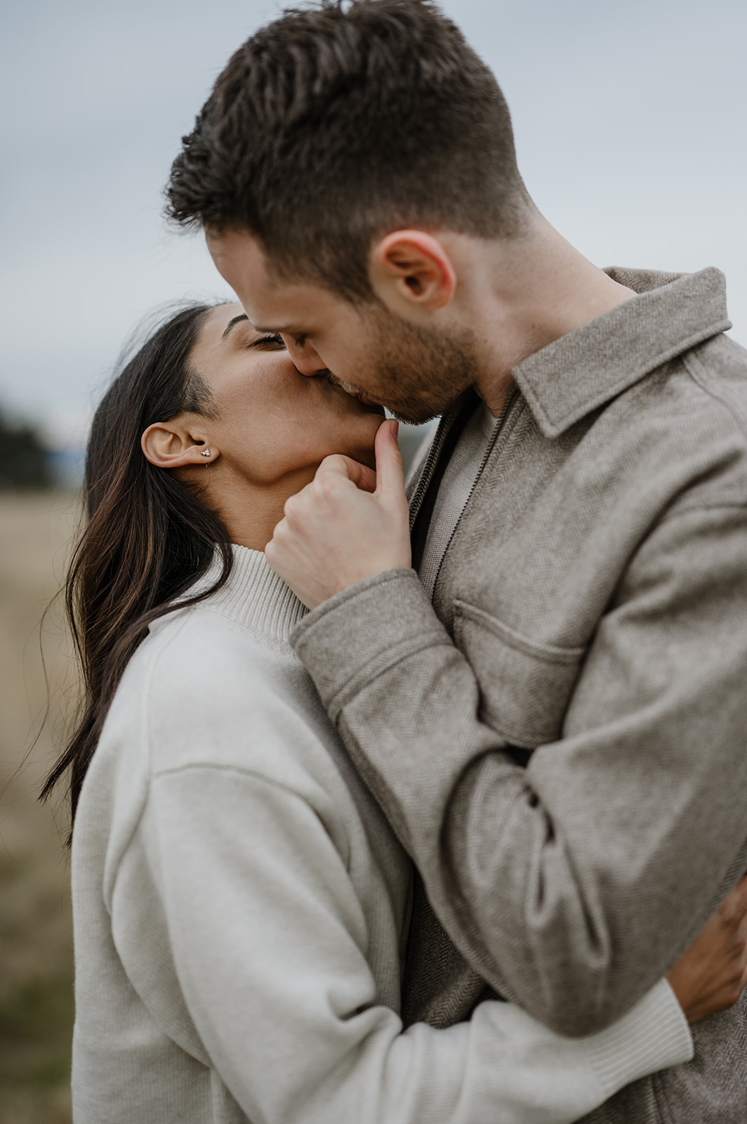 Couple shares a kiss in an intimate moment during their fall engagement session at Discovery Park.