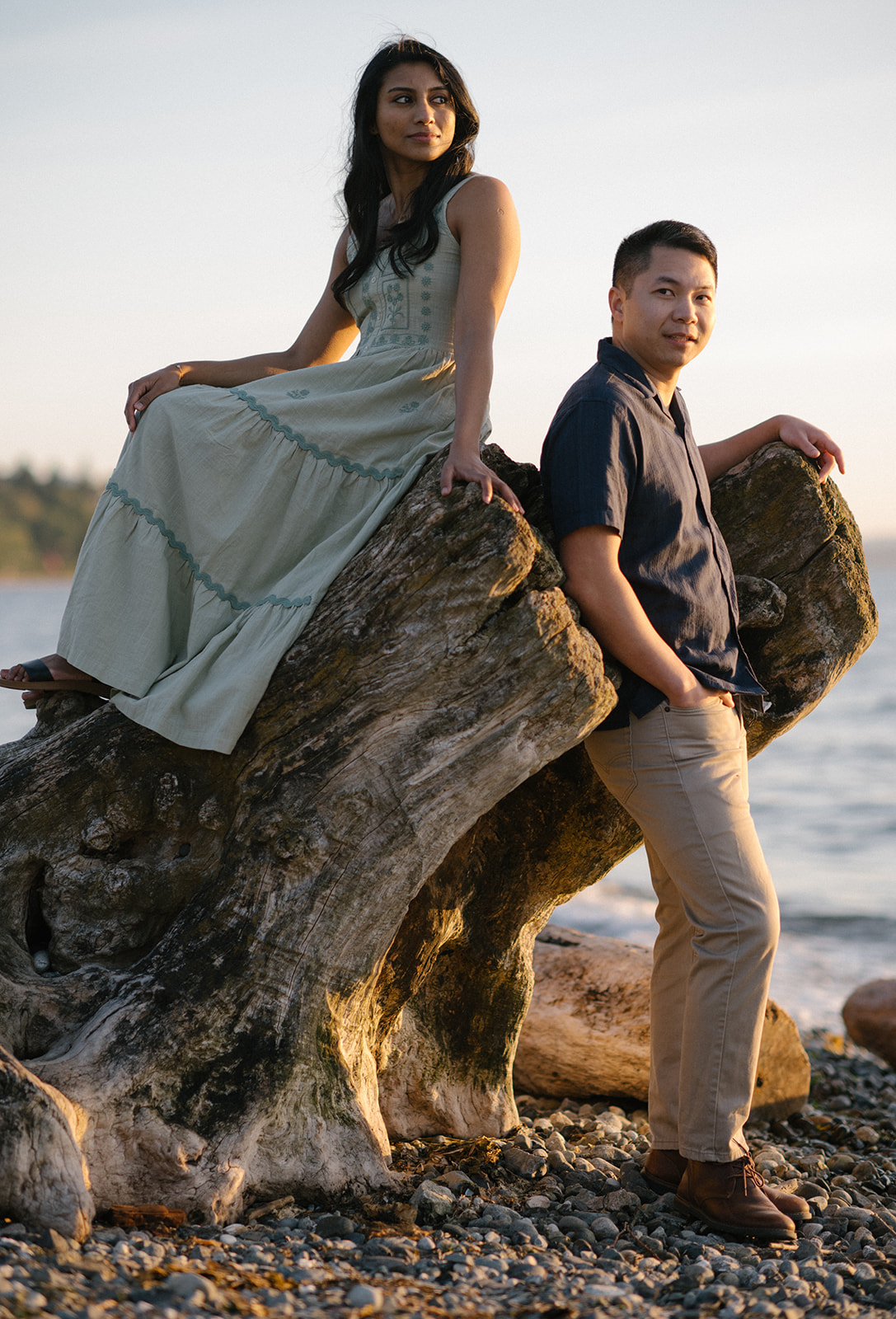 A couple enjoying a peaceful moment on a large driftwood at Carkeek Park.