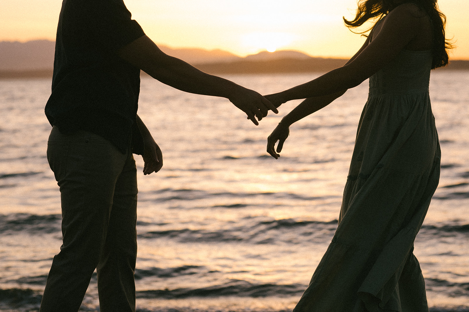 A close-up of a couple holding hands, focusing on their hands and connection.