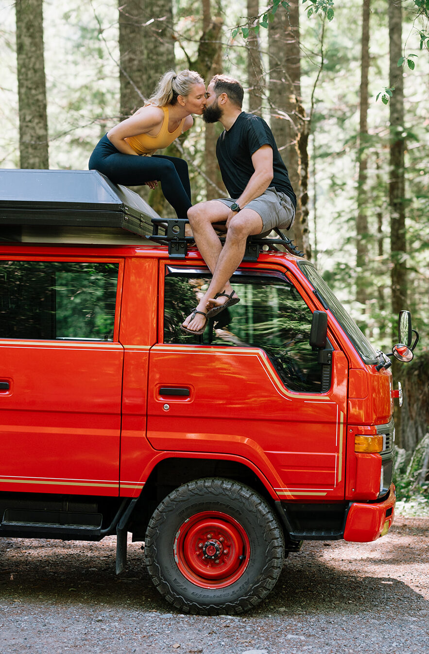 R and M kissing while sitting on the roof of their fire truck.