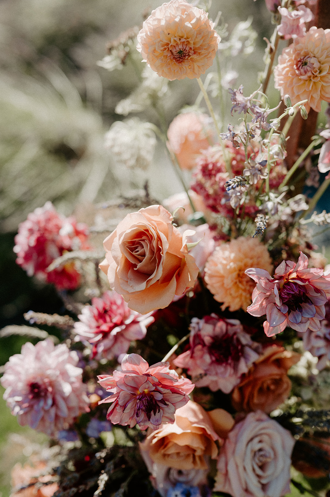 Close-up of peach and purple florals in ceremony arch arrangement