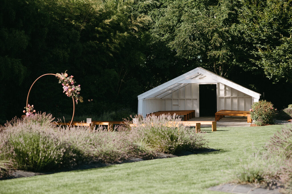 White open-air structure and floral arch in lavender field setting