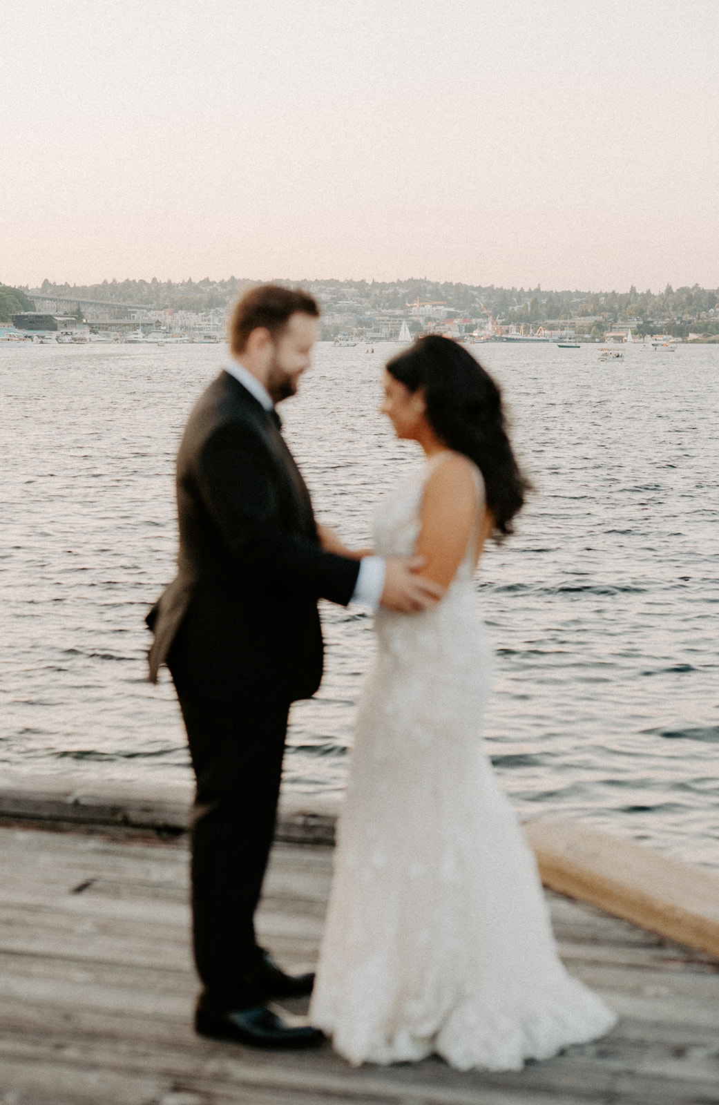 Bride and groom embracing near the water on a dock during their Dockside at Duke’s wedding.