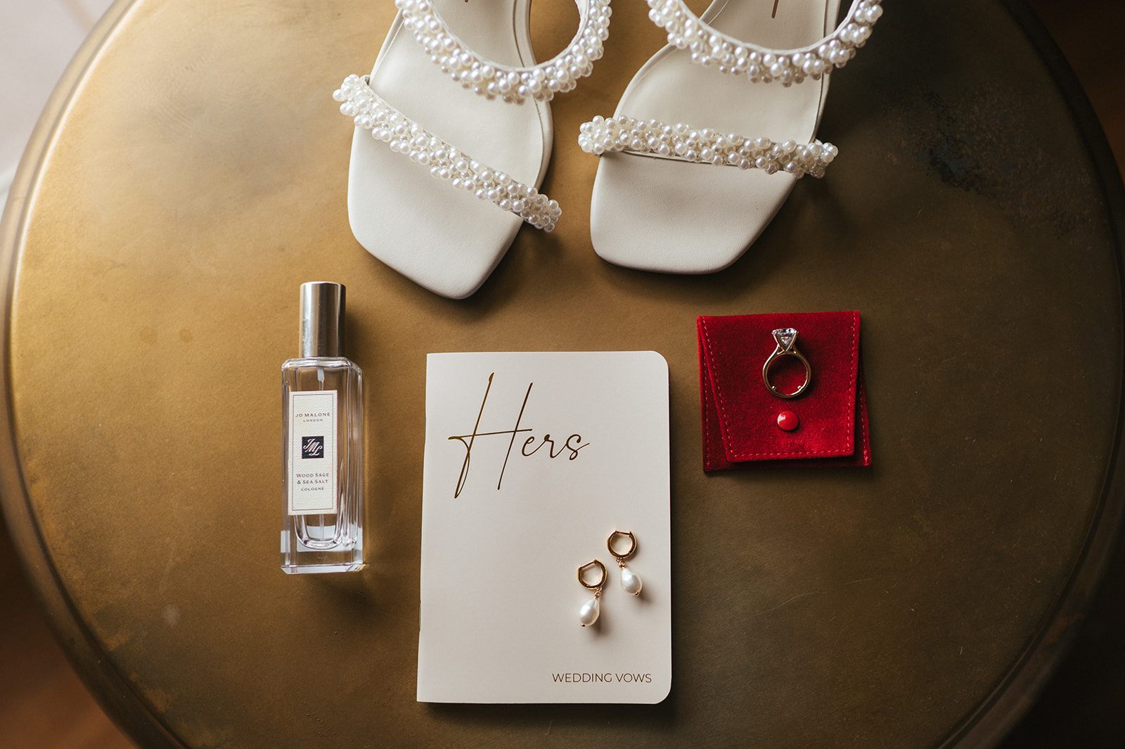 Bridal flat lay with white pearl-strap heels, wedding vows booklet, earrings, and perfume photographed at the Four Seasons Maui.