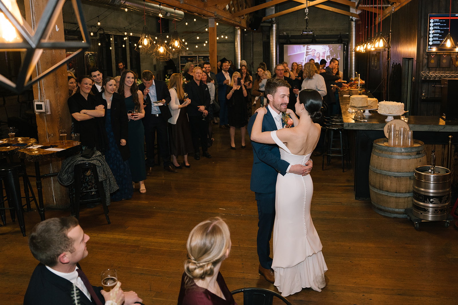 Bride and groom dancing while wedding guests look on at the reception venue.