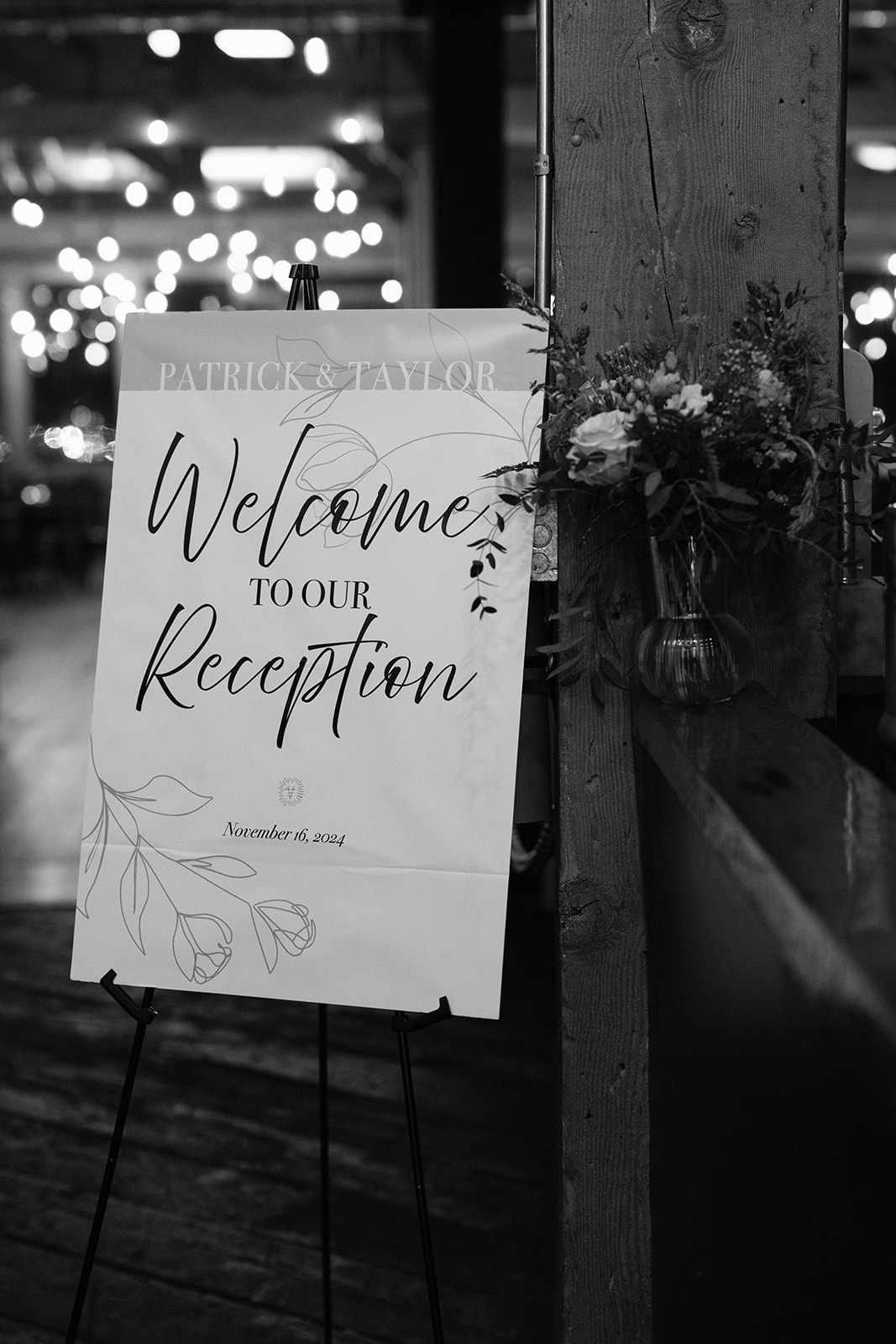 Reception welcome sign reading 'Welcome to our reception' next to a floral arrangement.