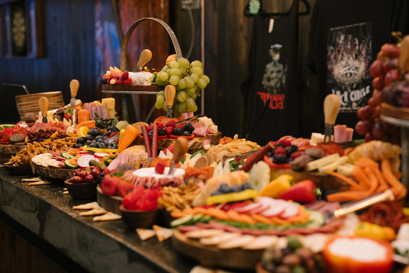 Elaborate charcuterie table featuring fruits, cheeses, and crackers at the wedding reception.