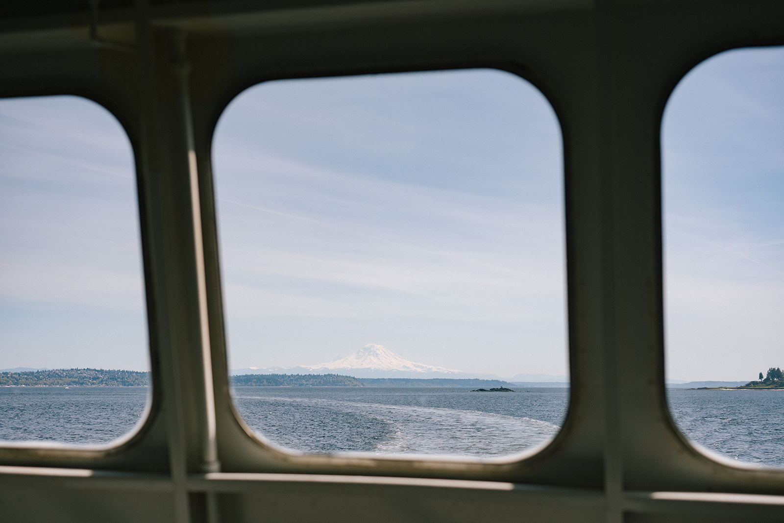 Mount Rainier framed by ferry windows over Puget Sound waters