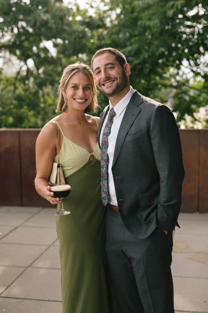 Wedding guests smiling together while holding drinks during cocktail hour at the Fremont Foundry