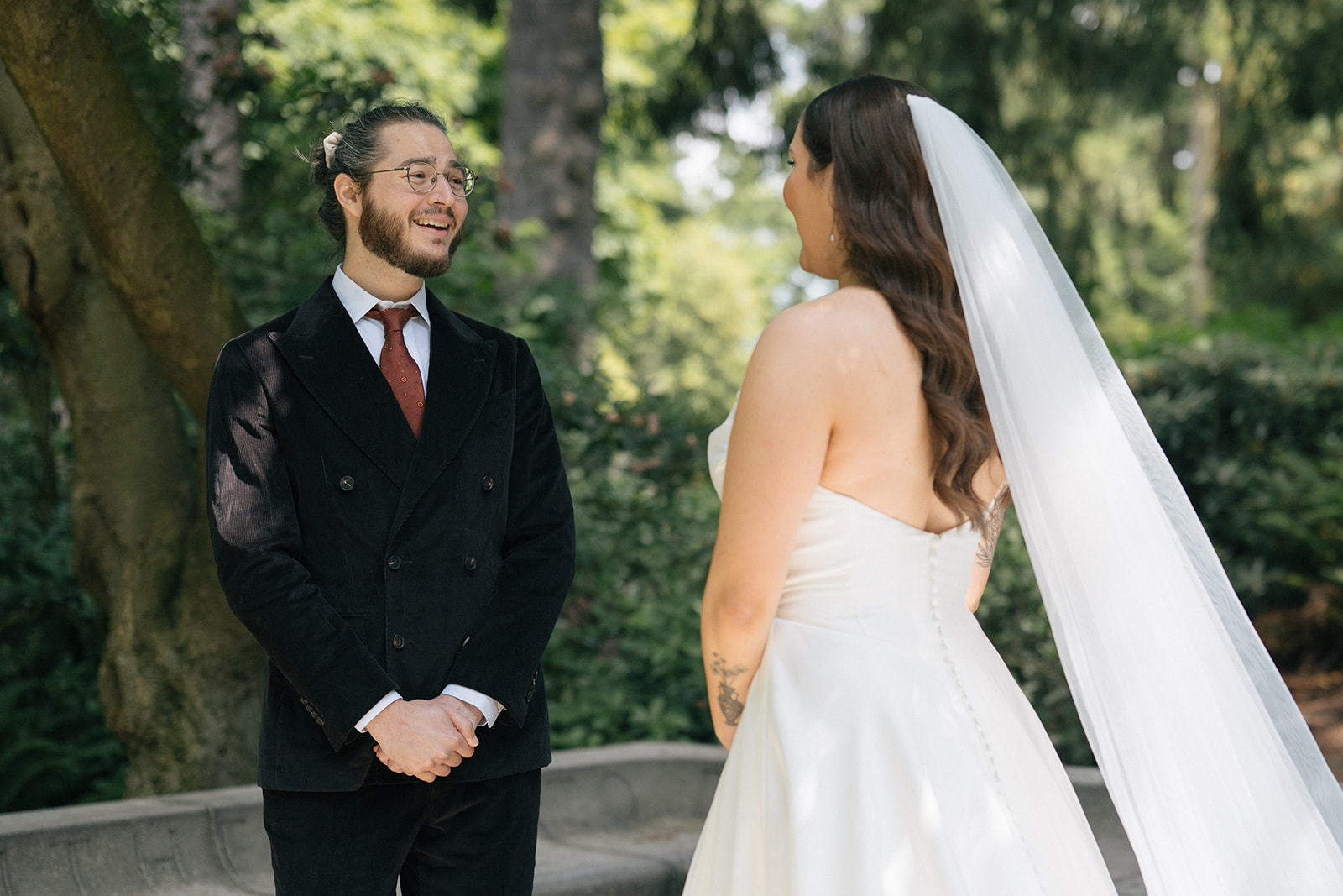Groom smiling emotionally as he sees his bride for the first time