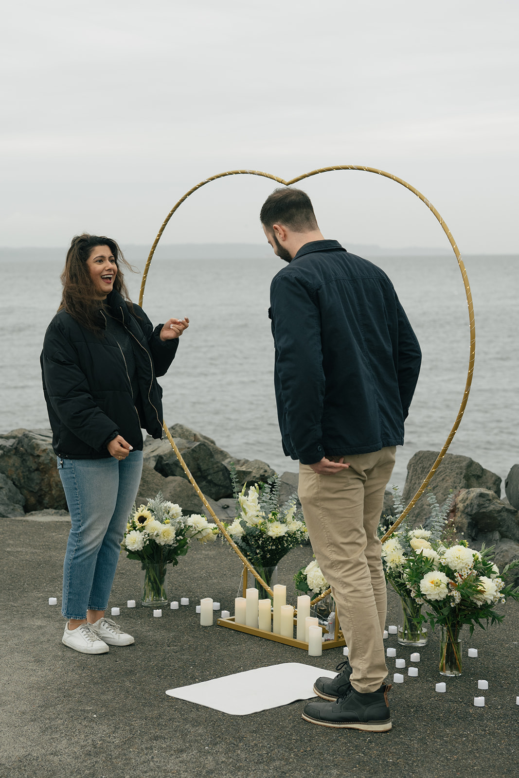 Aysha reacts in surprise as she sees the heart-shaped arch and candles set up by the water.