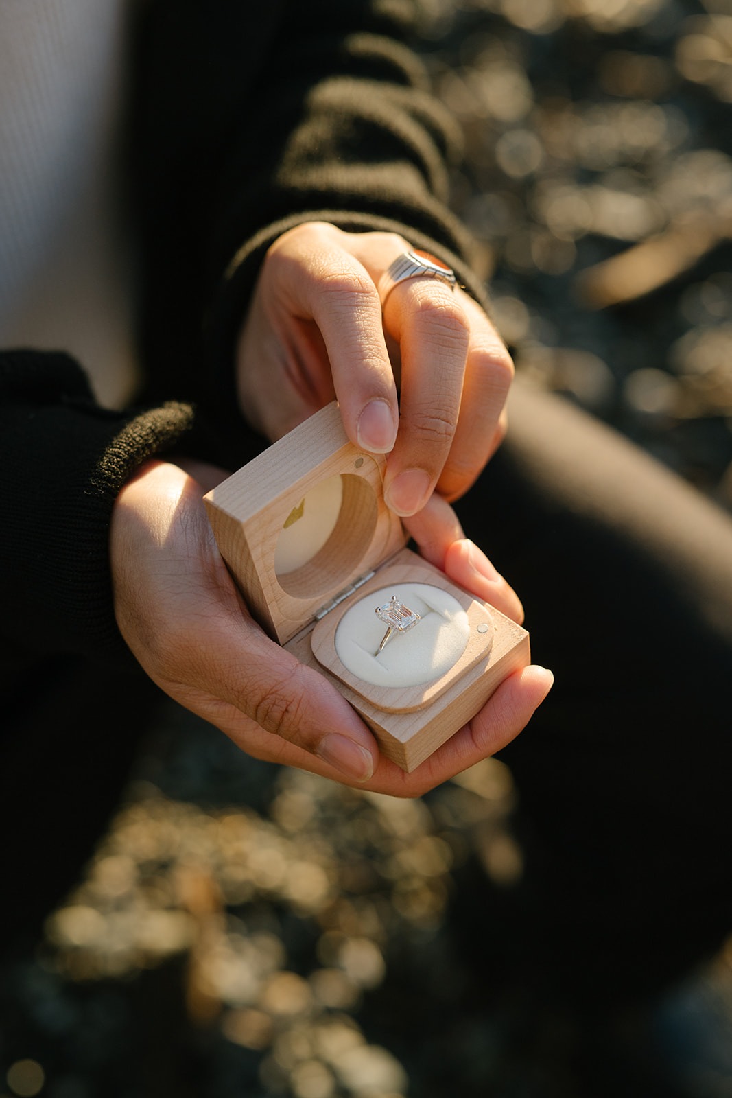 Radiant-cut diamond engagement ring in a handcrafted wooden ring box at a Seattle beach proposal