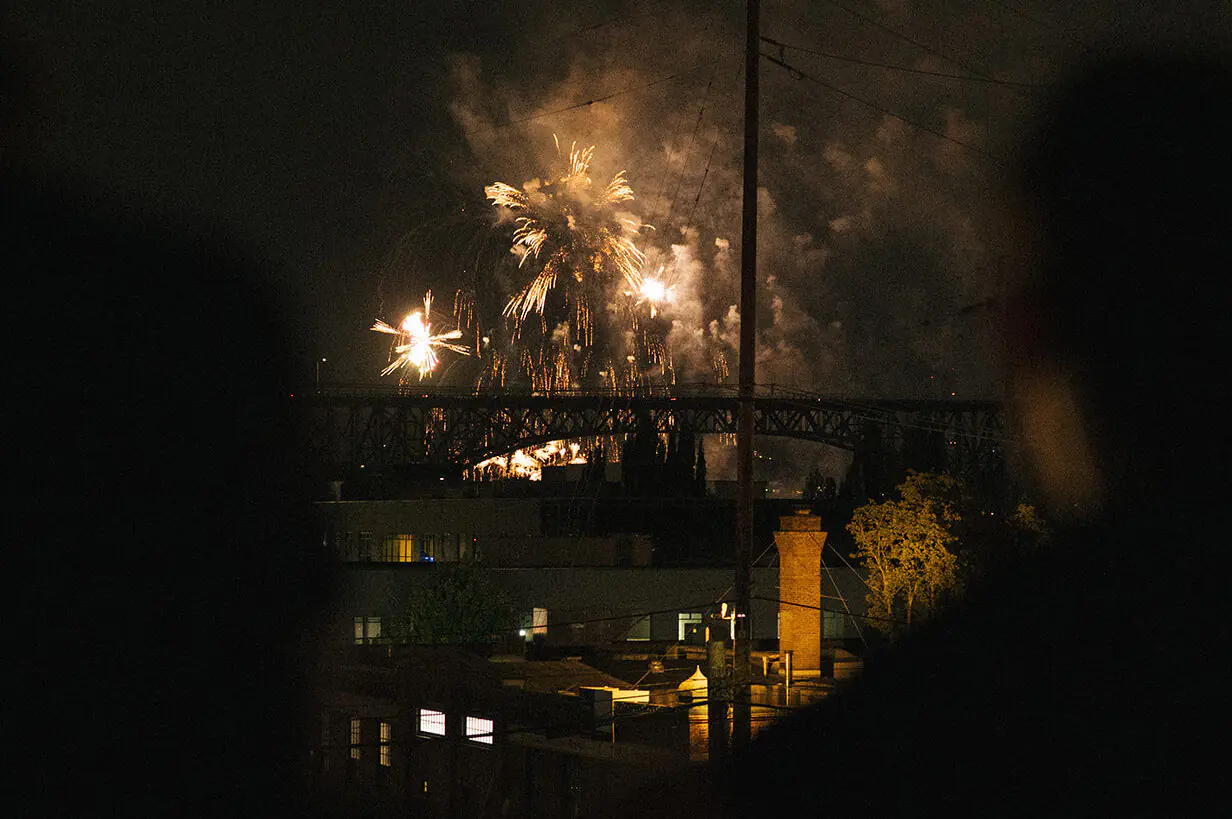 Fourth of July fireworks exploding over the Fremont Bridge and Lake Union as seen from a rooftop in Seattle