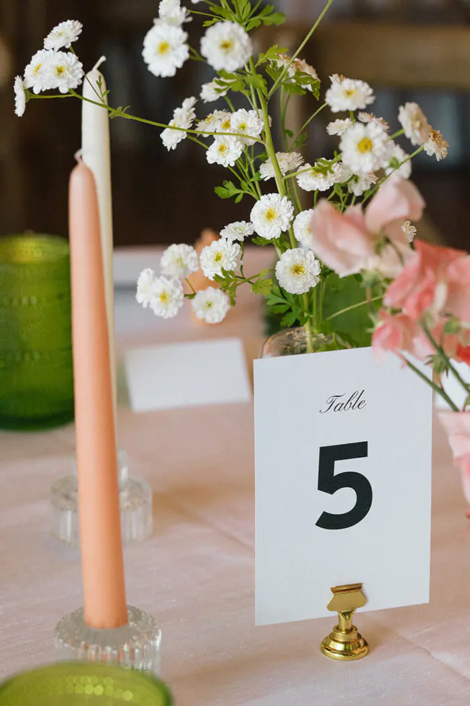 Table number five with pastel candles and garden-style floral centerpiece at a Fremont Foundry wedding