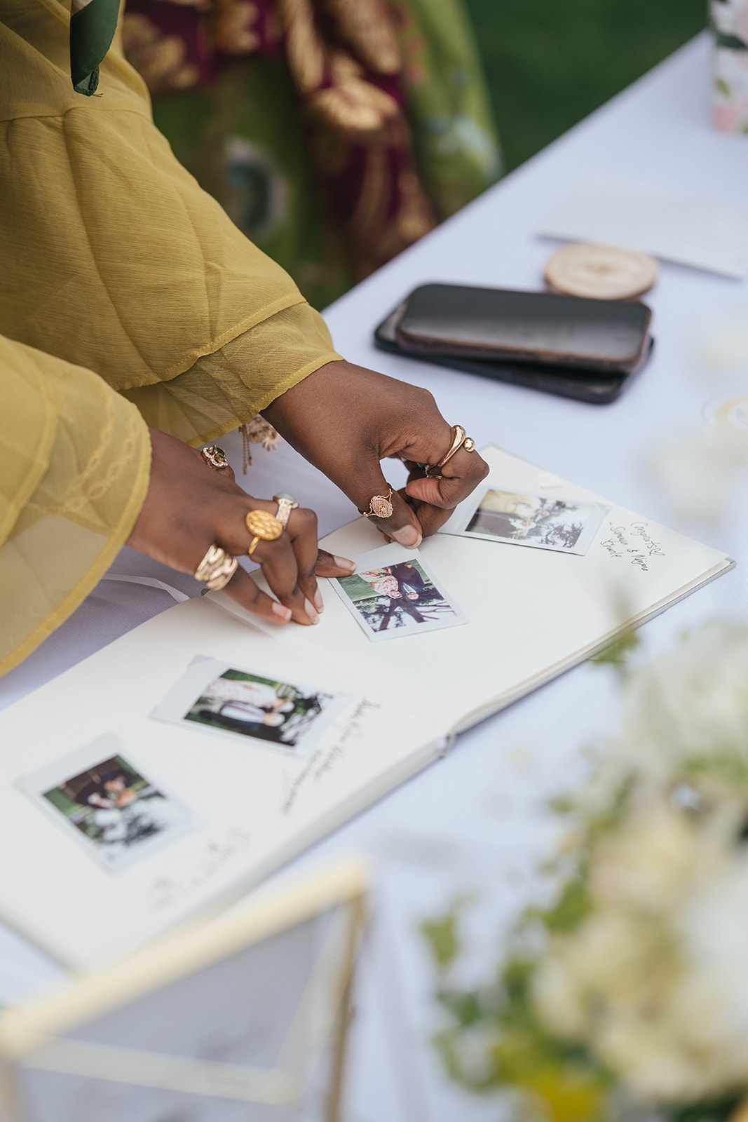 Wedding guest placing instant photos into a guestbook at Lairmont Manor wedding reception