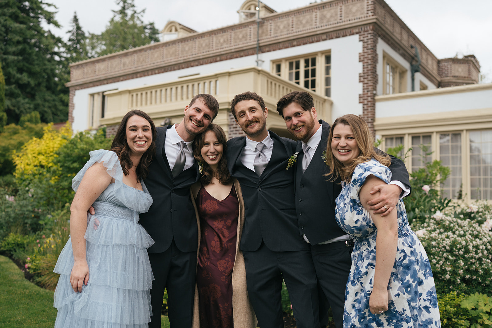 Wedding guests smiling together in front of Lairmont Manor during cocktail hour