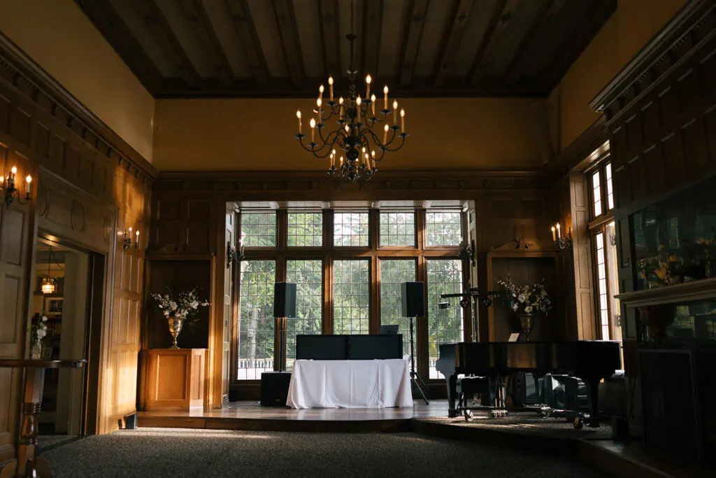 Elegant reception room with chandeliers and grand piano at Lairmont Manor