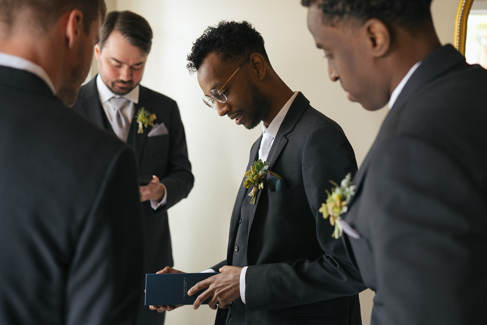 Groom opening a gift before the ceremony at Lairmont Manor
