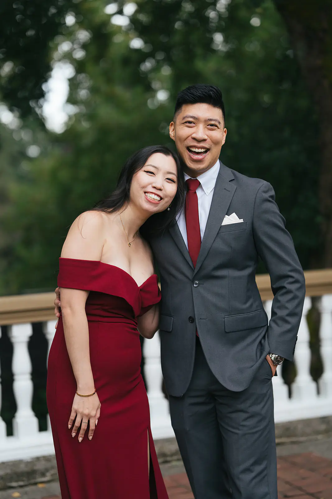 Couple dressed in formal attire posing together on the terrace at Lairmont Manor