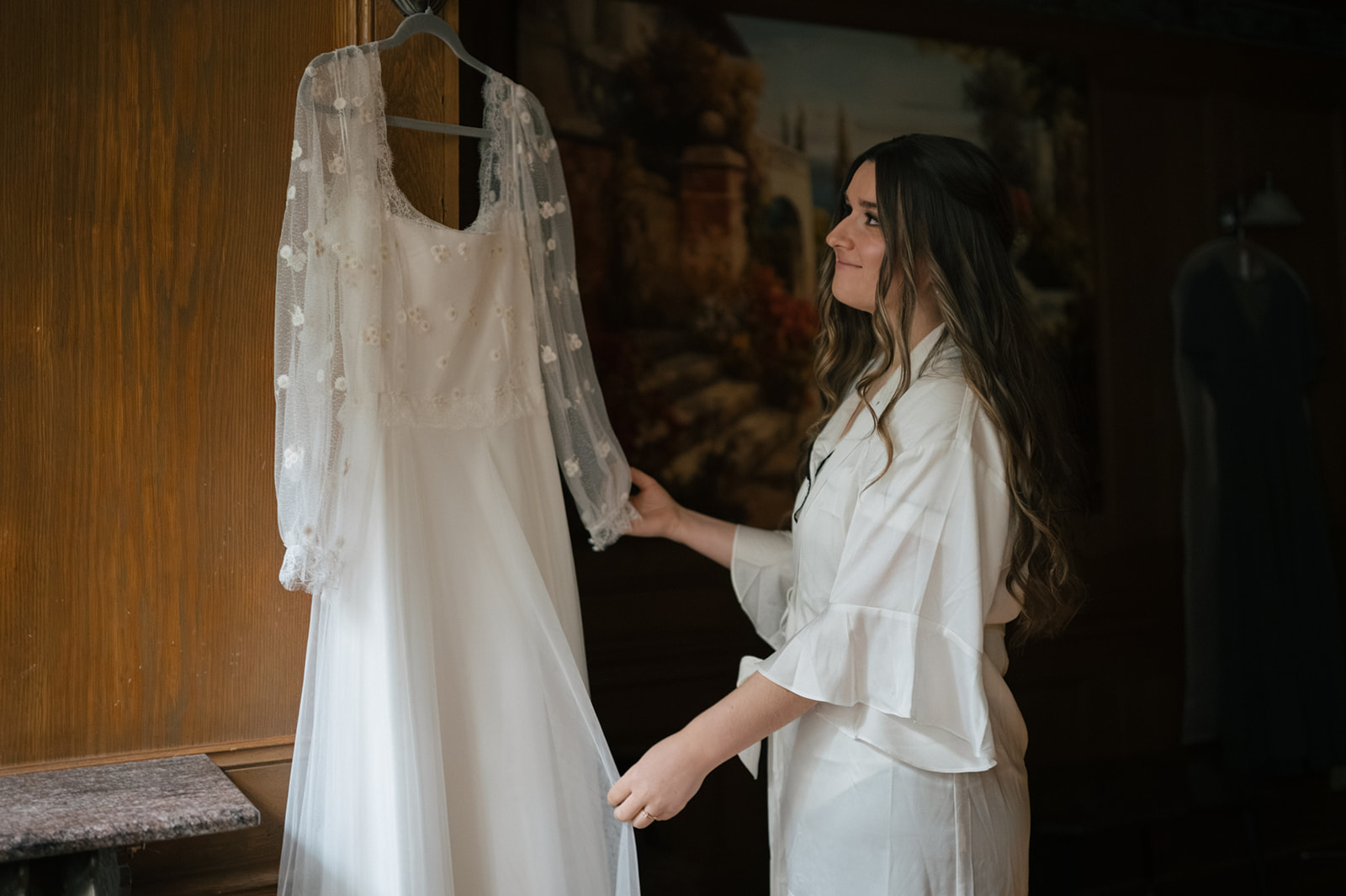 Bride holding wedding dress in getting ready suite at Lairmont Manor