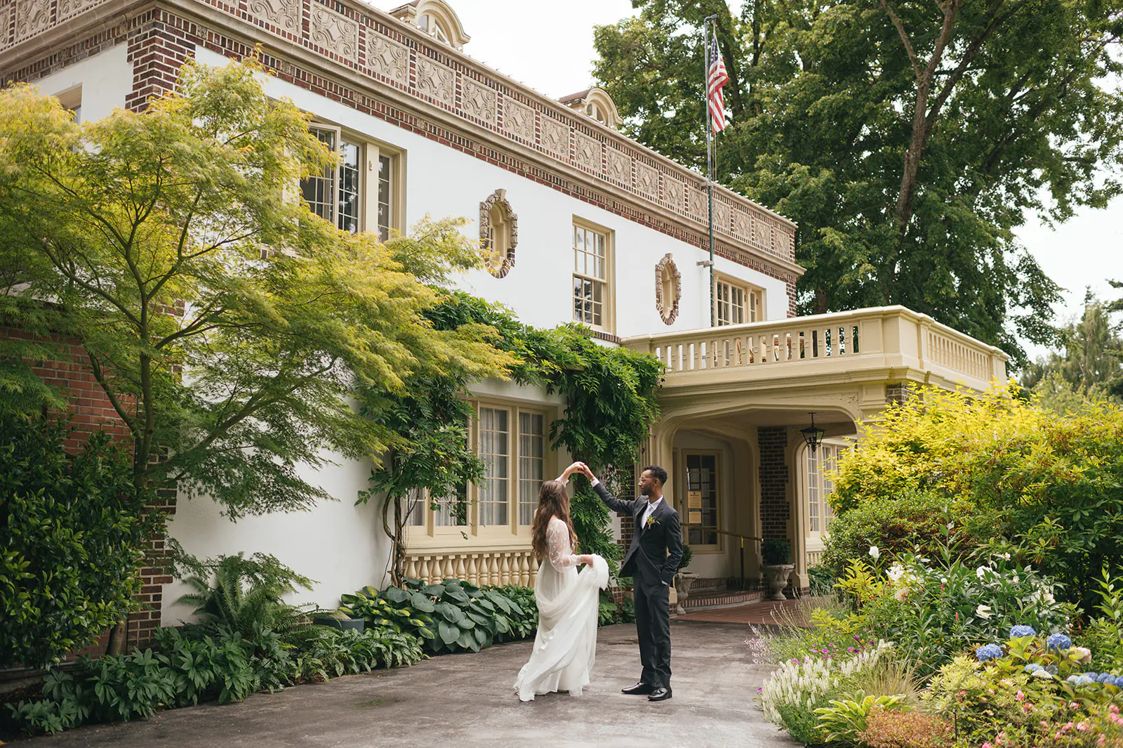 Groom twirling bride in the driveway outside Lairmont Manor during their first look portraits.