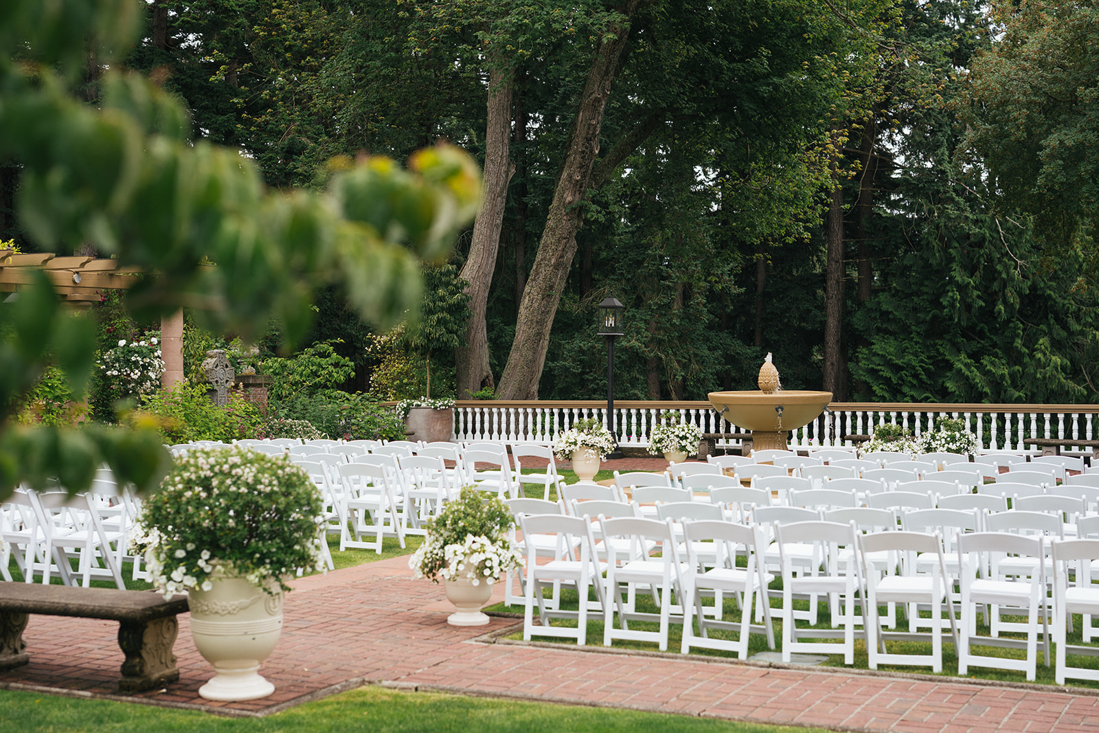 Outdoor garden ceremony setup at Lairmont Manor with white chairs and fountain in Bellingham Washington