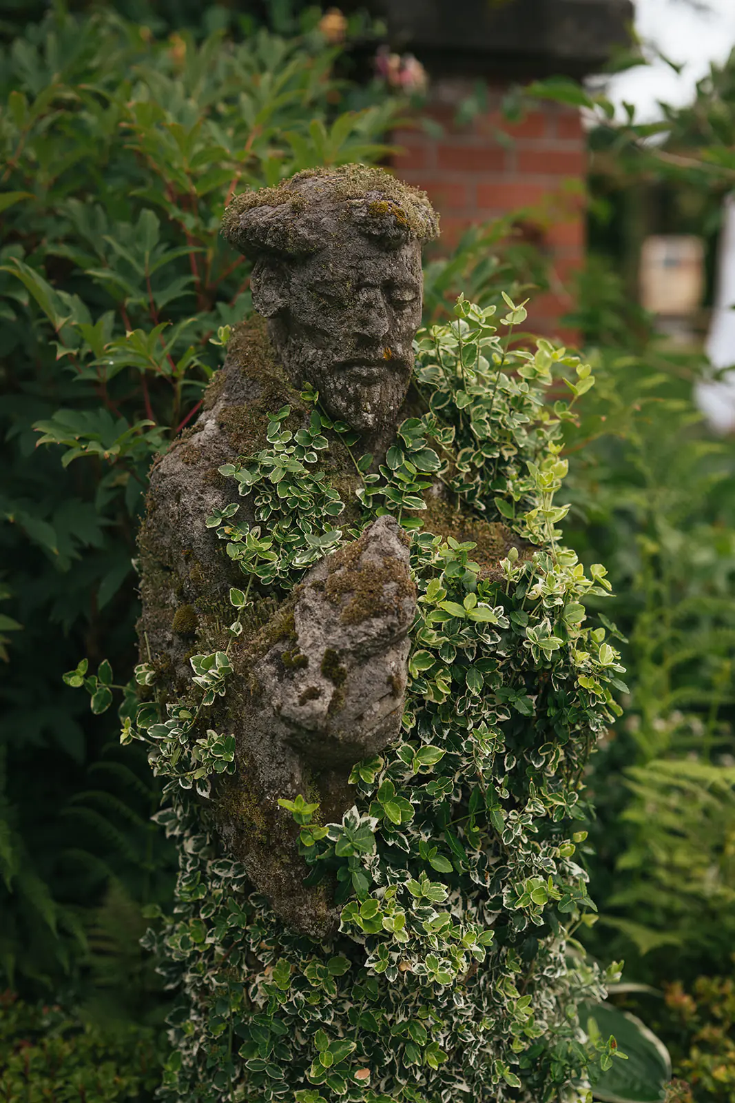Stone garden statue surrounded by ivy at Lairmont Manor in Bellingham Washington
