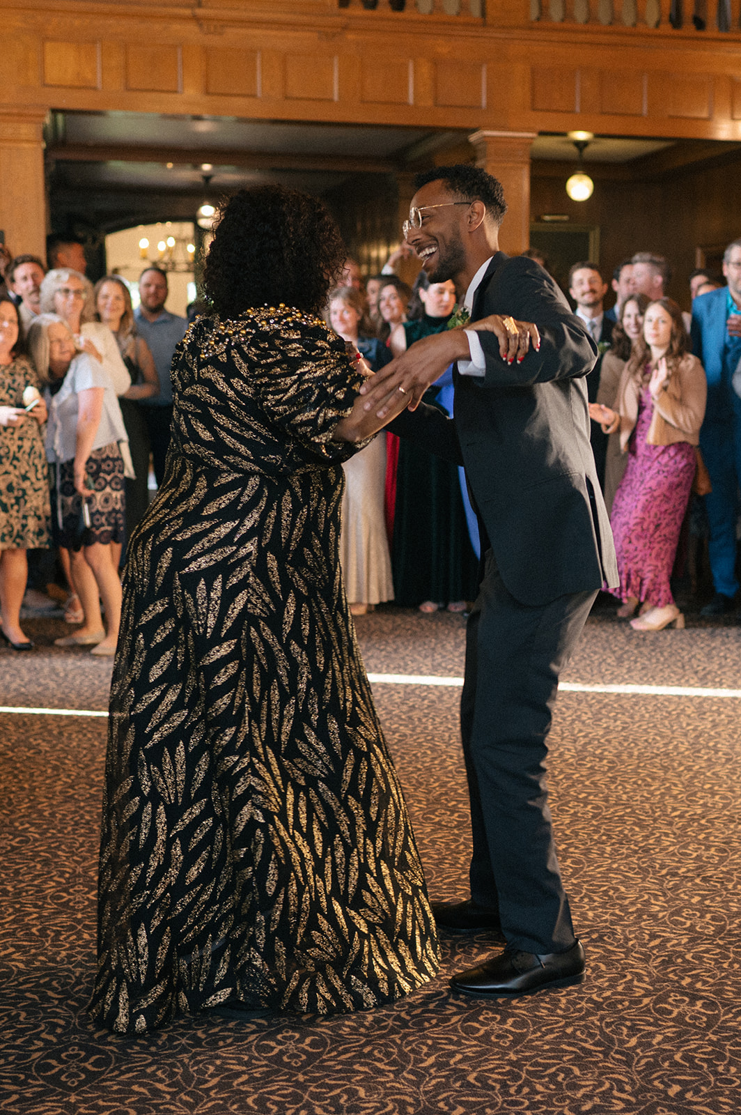 Groom twirling his mother across the dance floor during their mother-son dance at Lairmont Manor