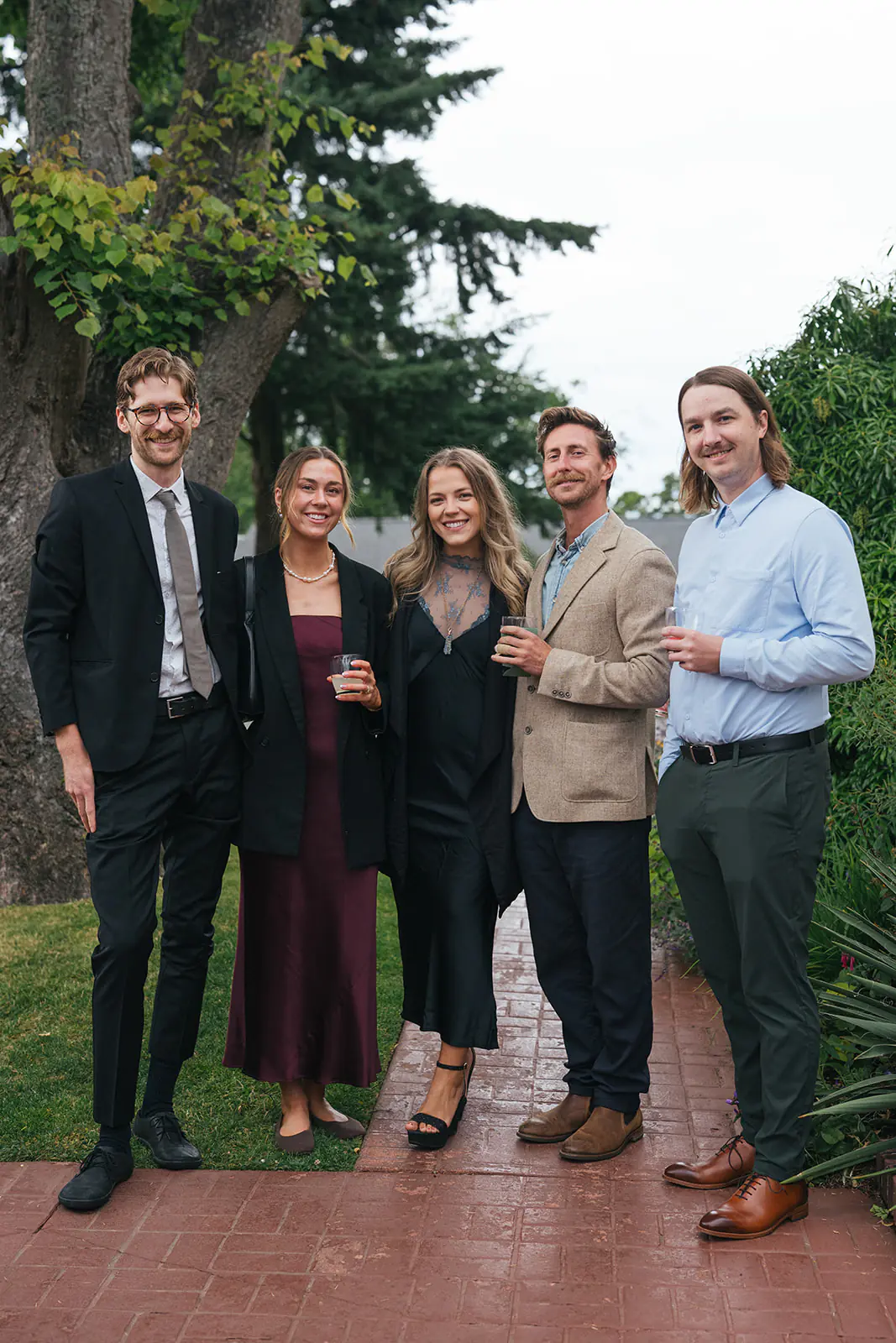Group of wedding guests posing together on a garden path at Lairmont Manor