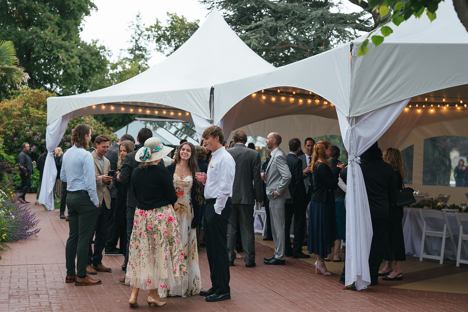 Wedding guests mingling beneath a white reception tent during cocktail hour at Lairmont Manor