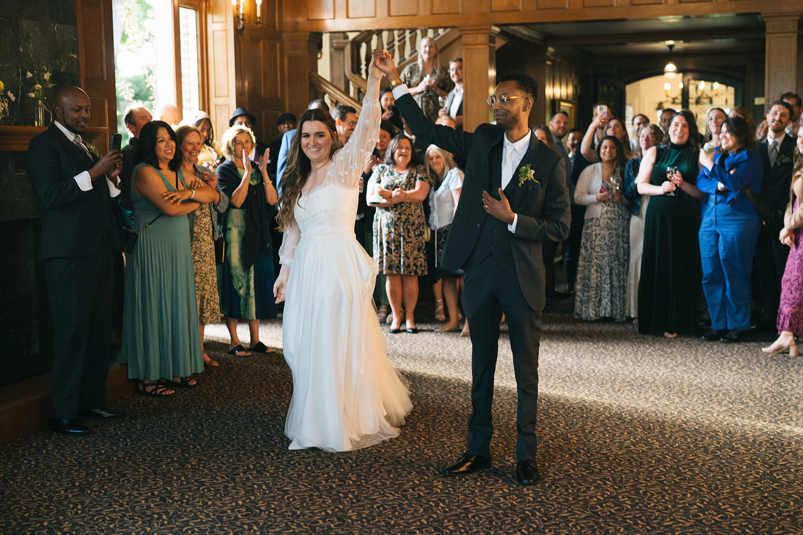 Bride raising her arm as she spins onto the dance floor with the groom during the reception at Lairmont Manor